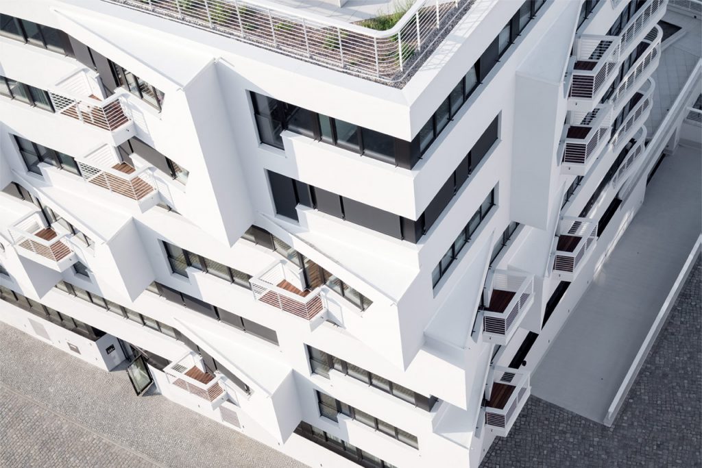 Spitz auskragende Erker und kantige Balkone gliedern die Fassade zur Straßenfront.